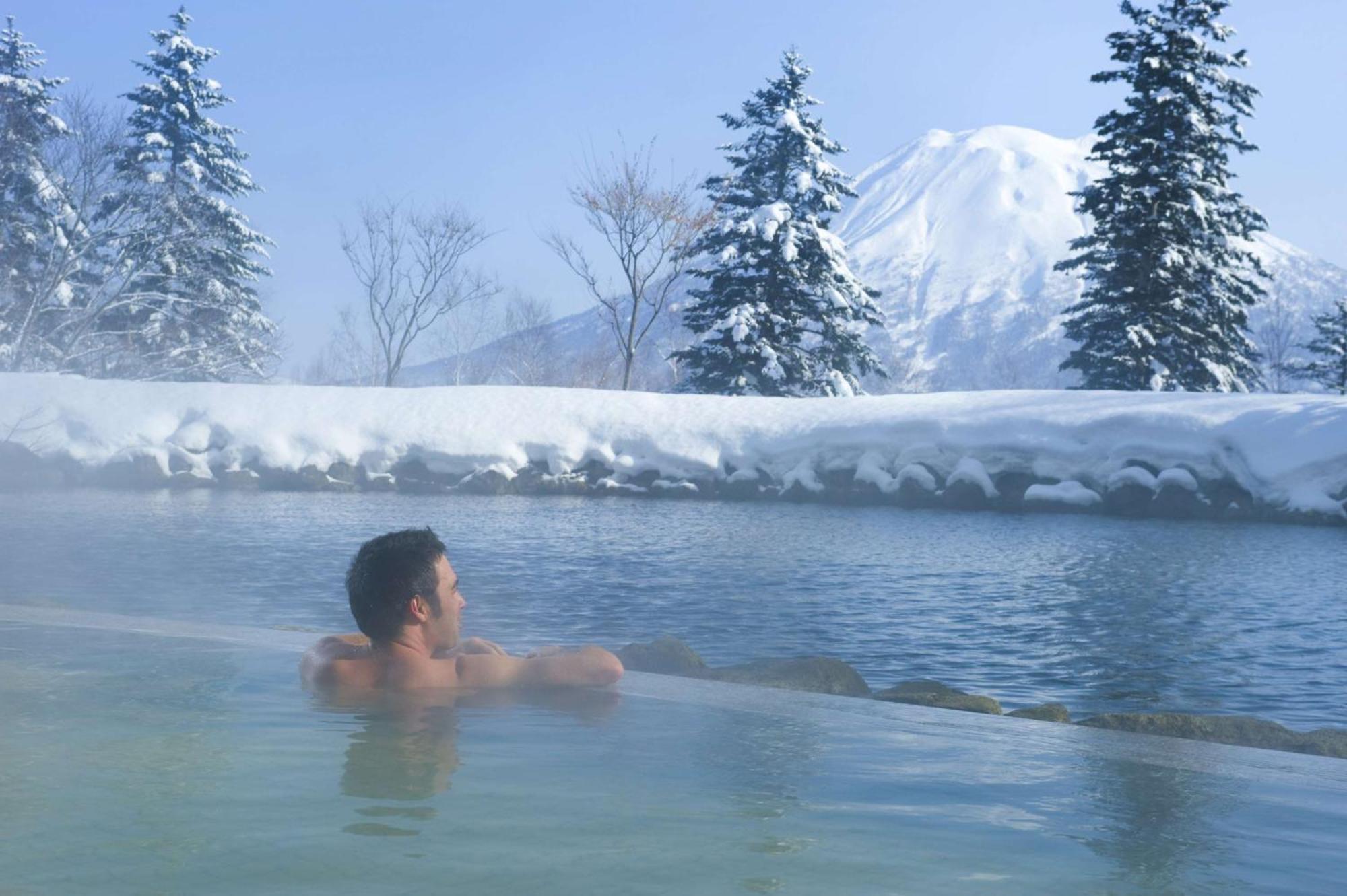 Hilton Niseko Village Dış mekan fotoğraf A man bathing in an open-air onsen